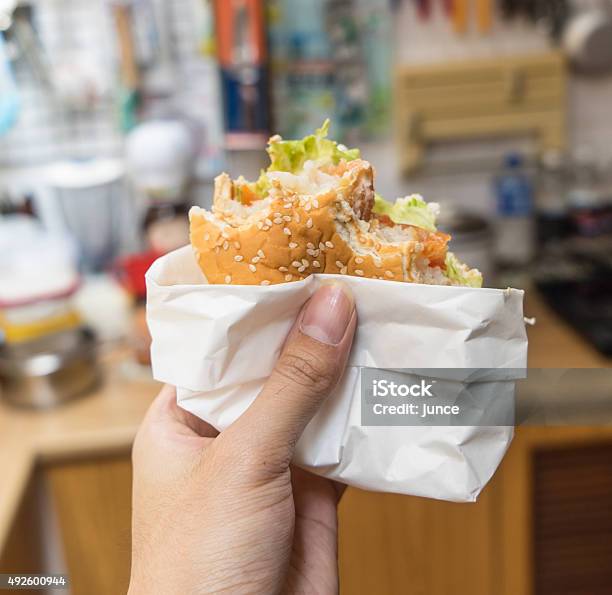 Holding Bitten Fish Burger Stock Photo - Download Image Now - 2015, Beef, Biting