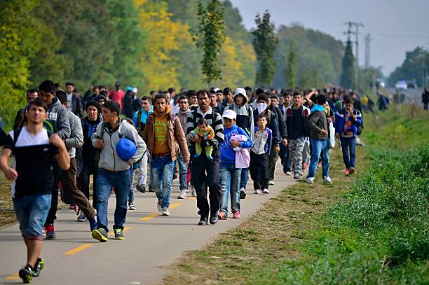 refugees leaving Hungary Hegyeshalom, Hungary - October 6, 2015:  Group of refugees leaving Hungary. They came to Hegyeshalom by train and then they leaving Hungary and go to Austria and then to Germany. Many of them escapes from home because of civil war. syria stock pictures, royalty-free photos & images