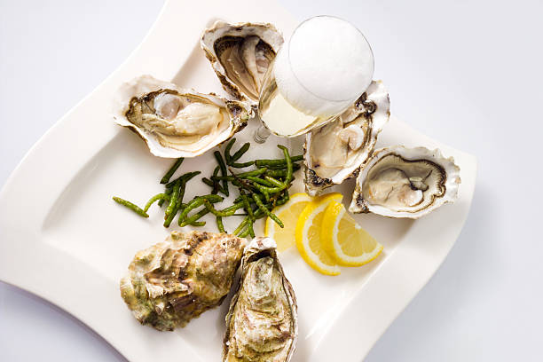 istock Oysters, lemon, seaweed, champagne glass on plate, white backgro 492603426