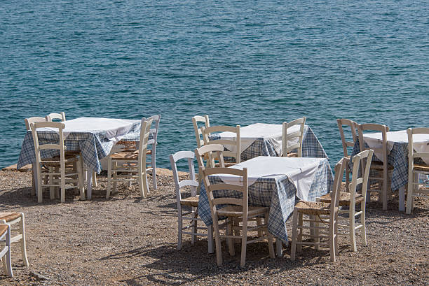 istock Wooden tables and chairs on a greek beach 492603824