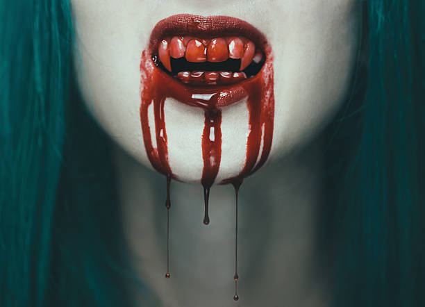 Scary vampire woman Scary vampire woman, close-up of mouth with teeth in blood. Halloween or horror theme vampire woman stock pictures, royalty-free photos & images