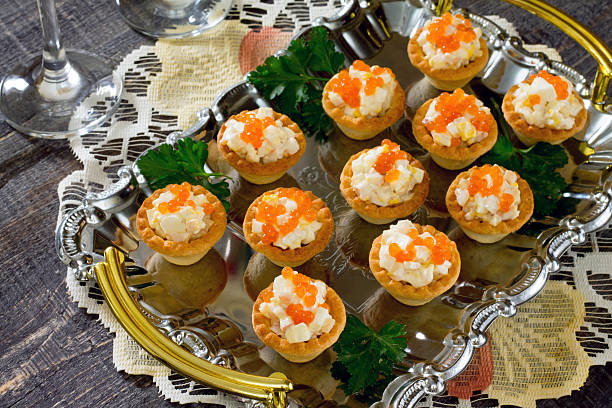 istock Tartlets with red caviar and squid on a wooden table 492605660
