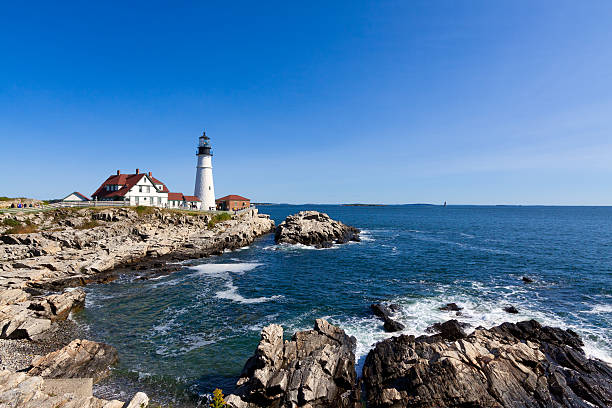 istock Portland Head Light, rocks, ocean surf, in morning. Blue sky. 492605972