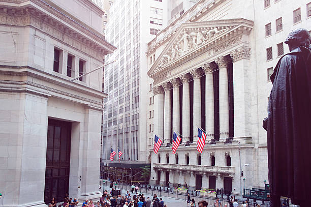 New York Stock Exchange, Wall street on summer morning. New York, United States - June 20, 2015: People walk near New York Stock Exchange alongside the Wall street on summer morning. lower manhattan stock pictures, royalty-free photos & images