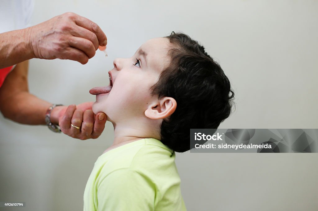 Childhood vaccination with droplet Childhood immunization action with little drop in clinic Vaccination Stock Photo