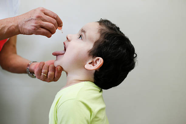 Childhood vaccination with droplet Childhood immunization action with little drop in clinic child liquid medicine stock pictures, royalty-free photos & images