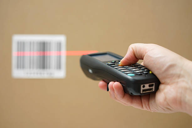 closeup of hand holding bar code scanner and scanning code closeup of hand holding bar code scanner and scanning code on cardboard box bar code reader stock pictures, royalty-free photos & images