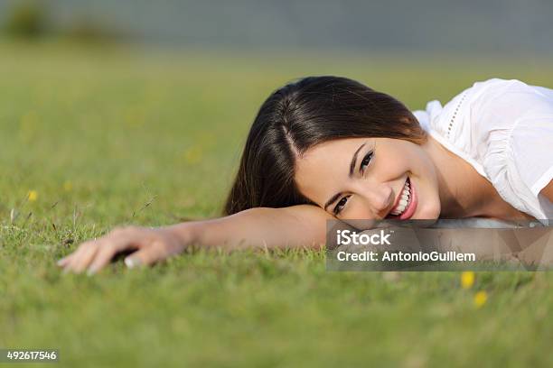 Happy Woman Smiling And Resting Relaxed On The Grass Stock Photo - Download Image Now