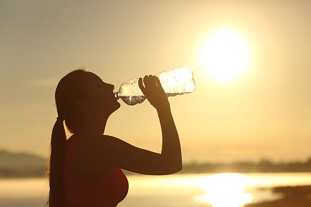 istock Fitness woman silhouette drinking water from a bottle 492619776