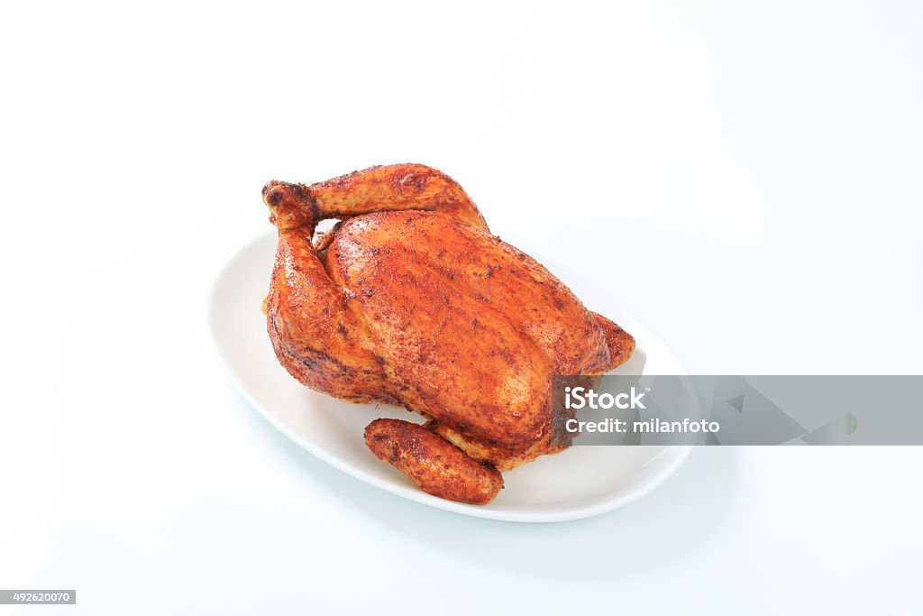 Roasted chicken Roasted whole chicken on a plate with fresh vegetables 2015 Stock Photo