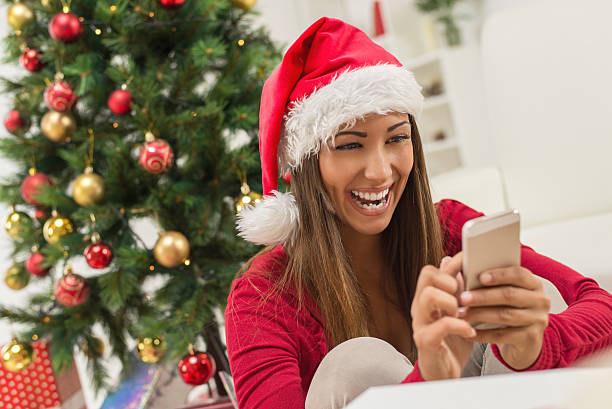 istock Girl With Santa's Hat And Smart Phone 492620734