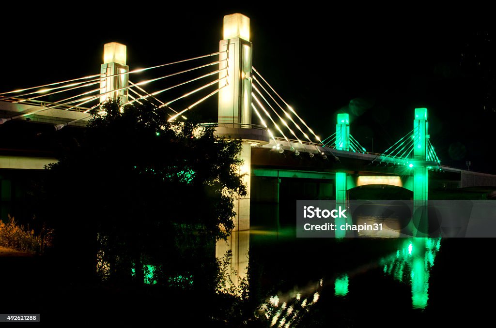 Night Shot of Pedestrian Bridge to McLane Stadium at Baylor One of two pedestrian bridges leading to McLane Stadium lit up in the Baylor colors of green and gold is reflected in the Brazos River.  McLane Stadium is the brand new football venue on the campus of Baylor University.  It stands on the banks of the Brazos River, providing the latest in sports and technology for unversity students and supporters, as well as an area along the river to provide "sail gating," where sailboats can tie off and celebrate the pregame atmosphere. Baylor University Stock Photo