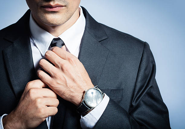 Businessman fixing his tie Businessman fixing his tie. man adjusting tie stock pictures, royalty-free photos & images