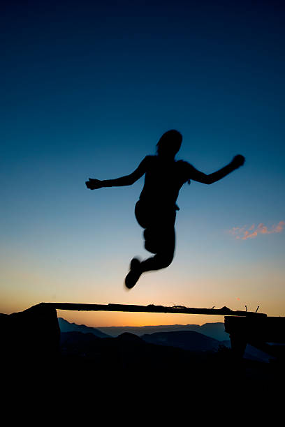 istock jumping over obstacles at sunset young girl day 492626094