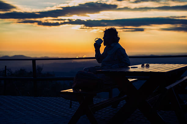 istock Silhouette of Man Drinking Coffee in the Mountains, Sunset 492629212