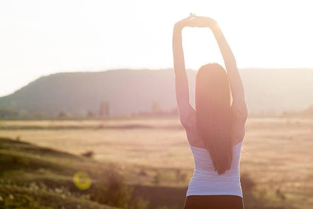 istock cheering woman open arms to sunrise 492630191