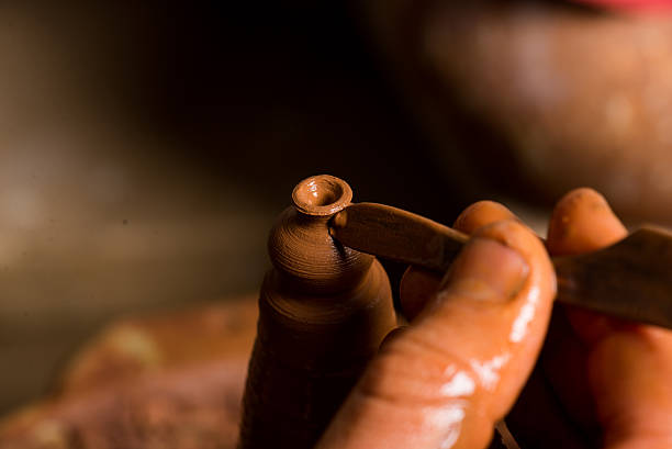 istock hands of a potter, creating an earthen jar 492630473