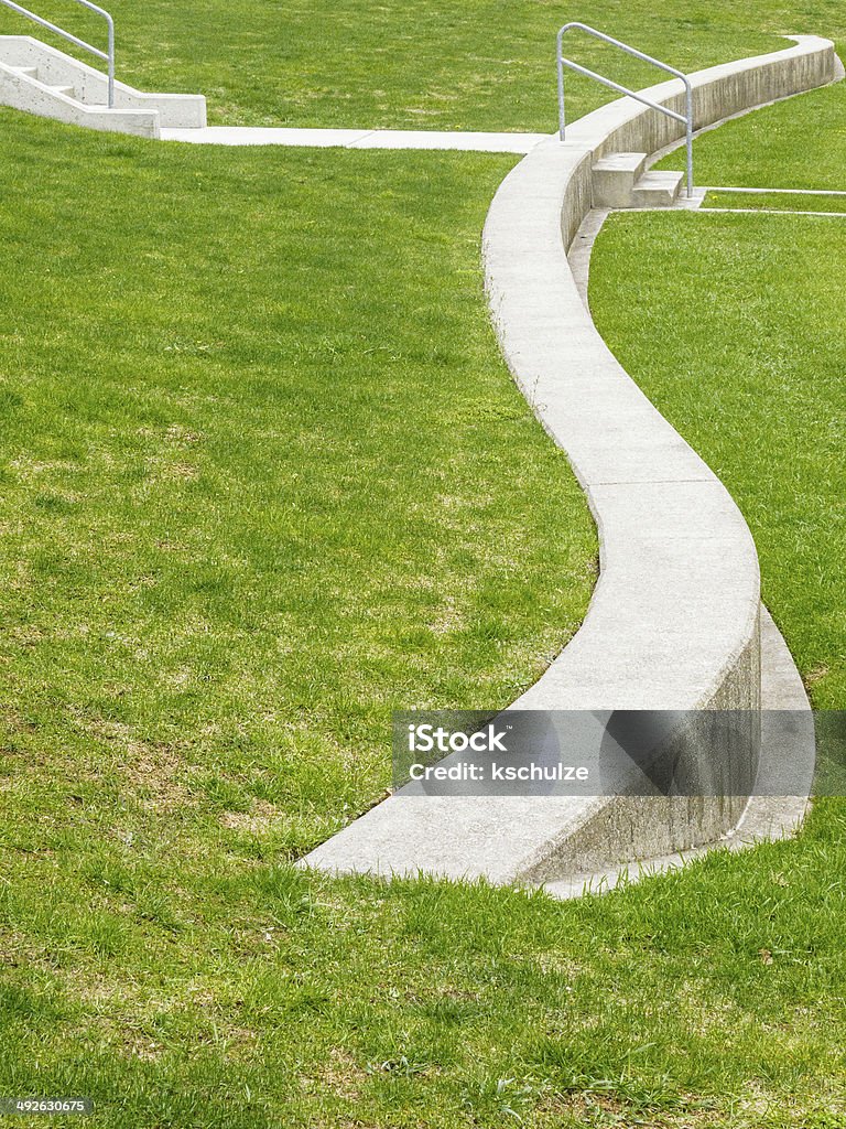 Amphitheater detail S-curved retaining wall of concrete on green lawn of outdoor amphitheater Amphitheater Stock Photo