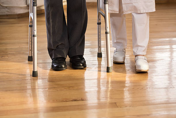 istock Nurse assisting a senior man with walking 492631048