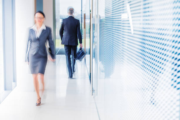 desfocado foto de pessoas de negócios caminhando no escritório moderno corredor - door office business women - fotografias e filmes do acervo