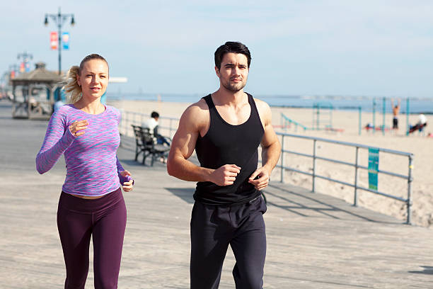 istock Man and woman jogging on boardwalk 492631626