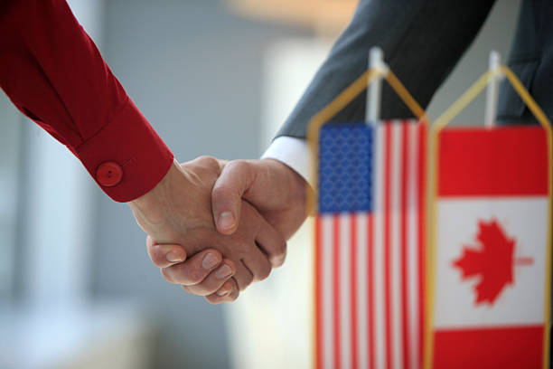 Handshake in front of usa and canada flags stock photo