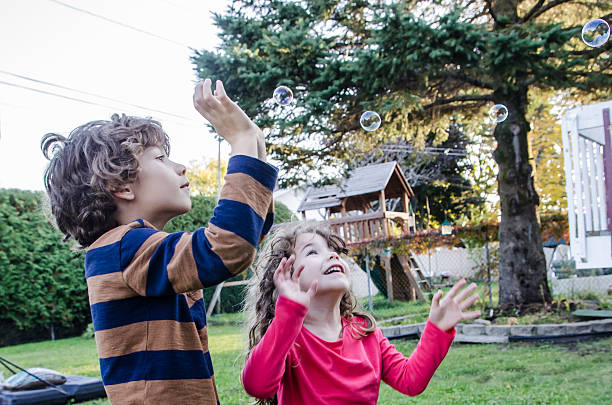 istock Two kids playing with soap bubble outside 492643760
