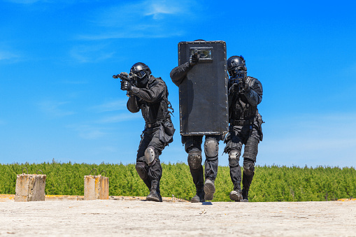 Spec ops police officers SWAT with ballistic shield in action