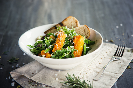Rocket salad with baked pumpkin, feta cheese, seeds and bread