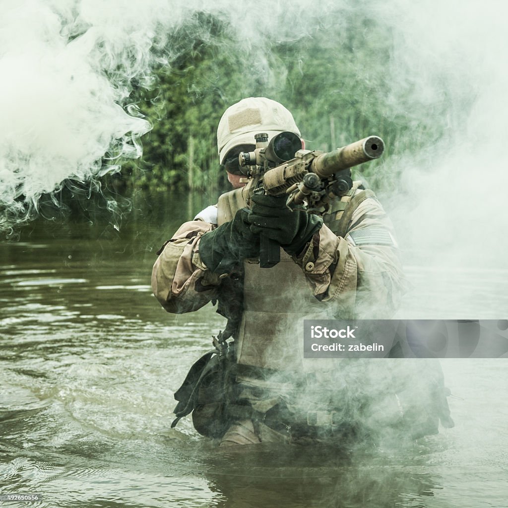 crossing the river Member of Navy SEAL Team crossing the river with weapons United States Navy SEALs Stock Photo