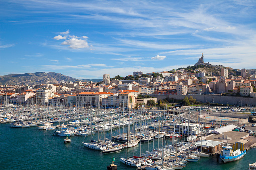 The Old Port is the main popular place in Marseille. The Port is overcrowded with yachts and fishing boats. Basilica Notre-Dame de la Garde on top of the hill on the right side of the picture.