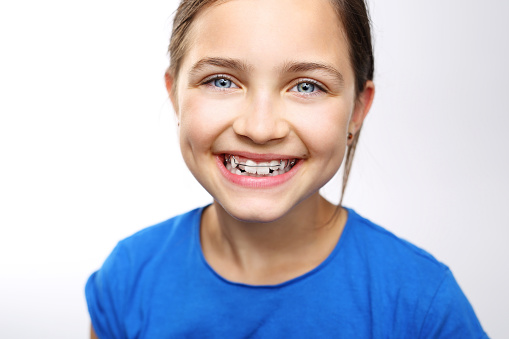 Portrait of a little girl with orthodontic appliance .
