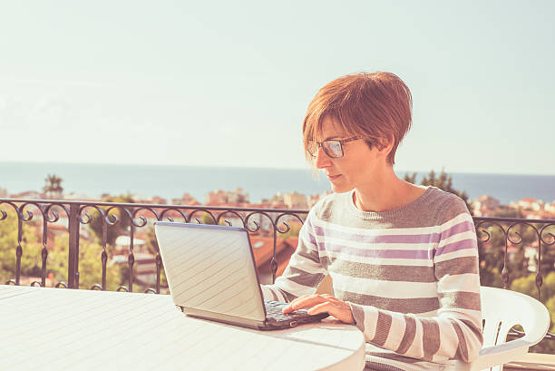 istock Woman working at home with netbook outdoors 492654764