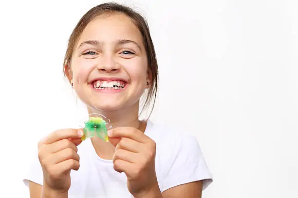 Portrait of a little girl with orthodontic appliance .