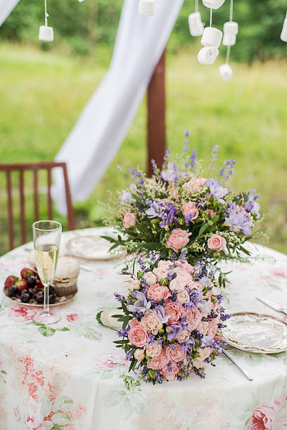 Served table outdoors. Flower arrangement with lavender and roses. Wedding