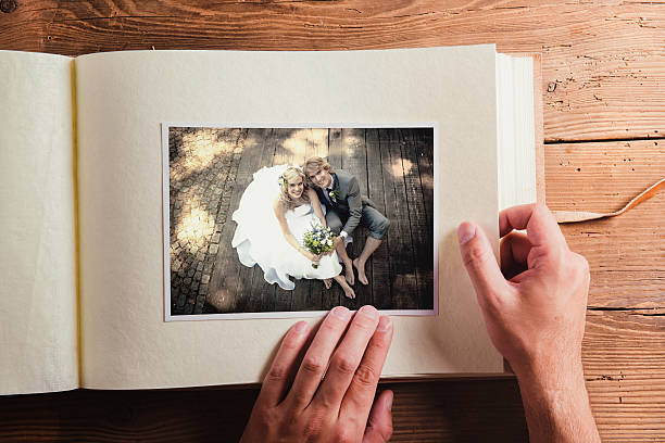 Wedding photo Picture of bride and groom in photo album. Studio shot on wooden background. scrapbook stock pictures, royalty-free photos & images