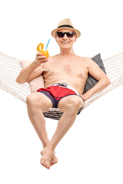 istock Senior lying in a hammock and drinking a cocktail 492665506
