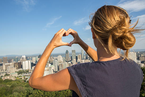 istock Young cheerful woman in Montreal-Canada making heart shape with hands 492669378