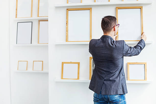 istock man hanging a blank poster in exhibition hall 492670574