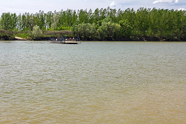 istock People are moving manual ferry boat across the river. 492670756