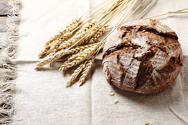 pan en rustic fondo negro - pan de centeno fotografías e imágenes de stock