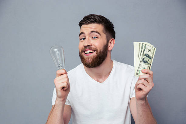 istock Smiling man holding bulb and dollar bills 492674970
