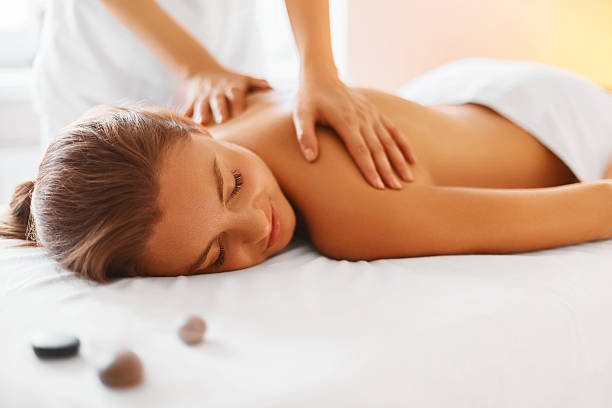 mujer spa. hembra de disfrutar de una sesión de masajes en el centro de spa. - dar masajes fotografías e imágenes de stock
