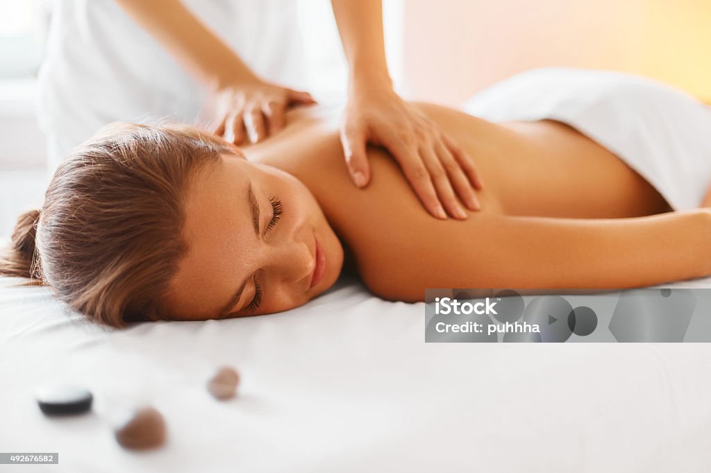 Spa Woman. Female Enjoying Massage in Spa Centre. Spa woman. Female enjoying relaxing back massage in cosmetology spa centre. Body care, skin care, wellness, wellbeing, beauty treatment concept. Massaging Stock Photo
