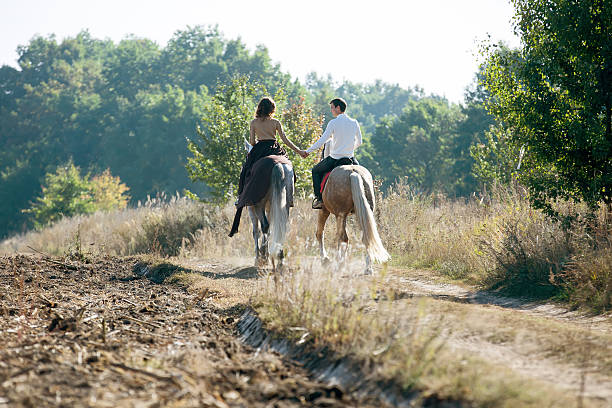 istock Young couple in love riding a horse 492677172
