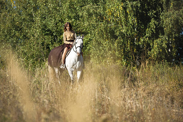hermosa chica montando a caballo blanco - cowboy blue meadow horizontal fotografías e imágenes de stock