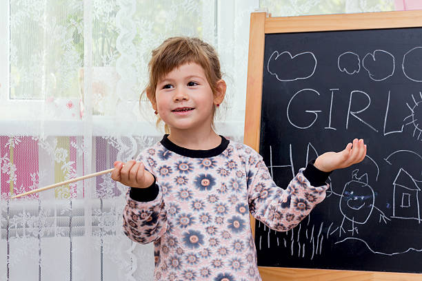 istock Little beautiful girl drawing on a blackboard. 492680266