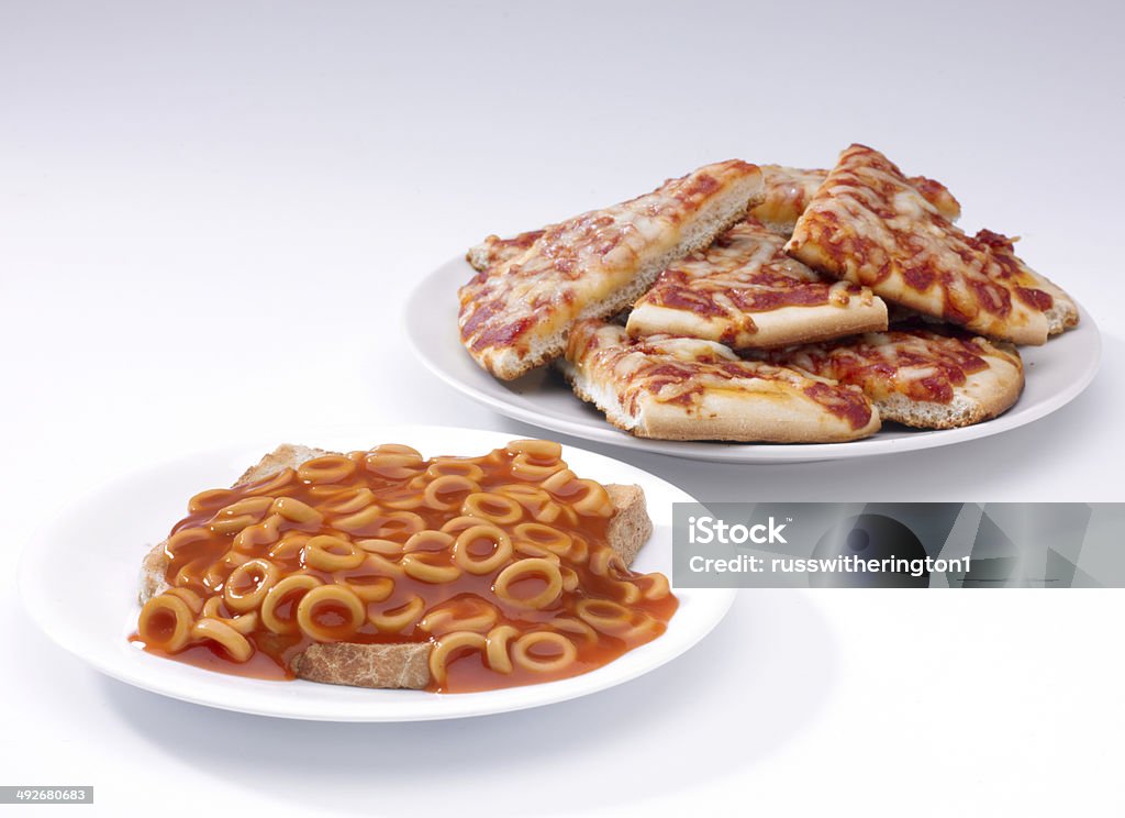 Spaghetti hoops and pizza a serving of spaghetti hoops on toast and a plate of pizza slices on a white plate on a white background Buffet Stock Photo