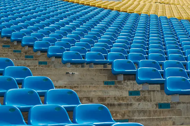 A field of empty blue plastic stadium seats.
