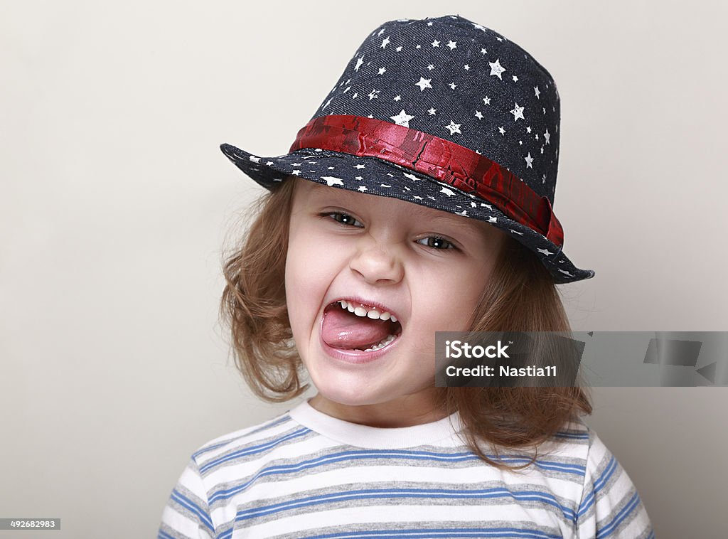 Funny grimacing kid in hat showing the tongue Cheerful Stock Photo